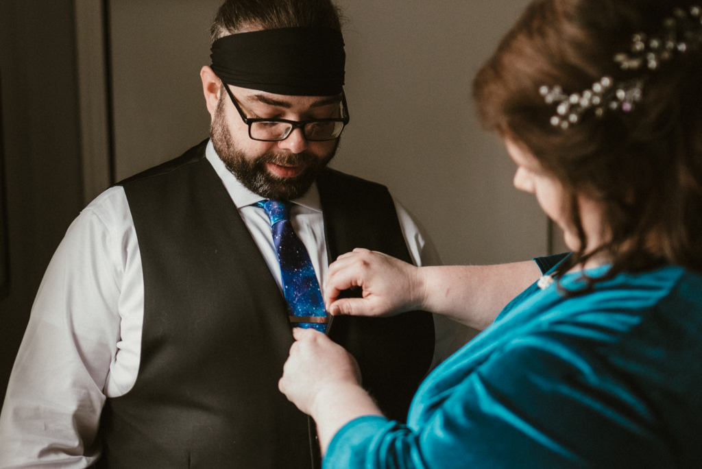 Bride helping groom with his tie