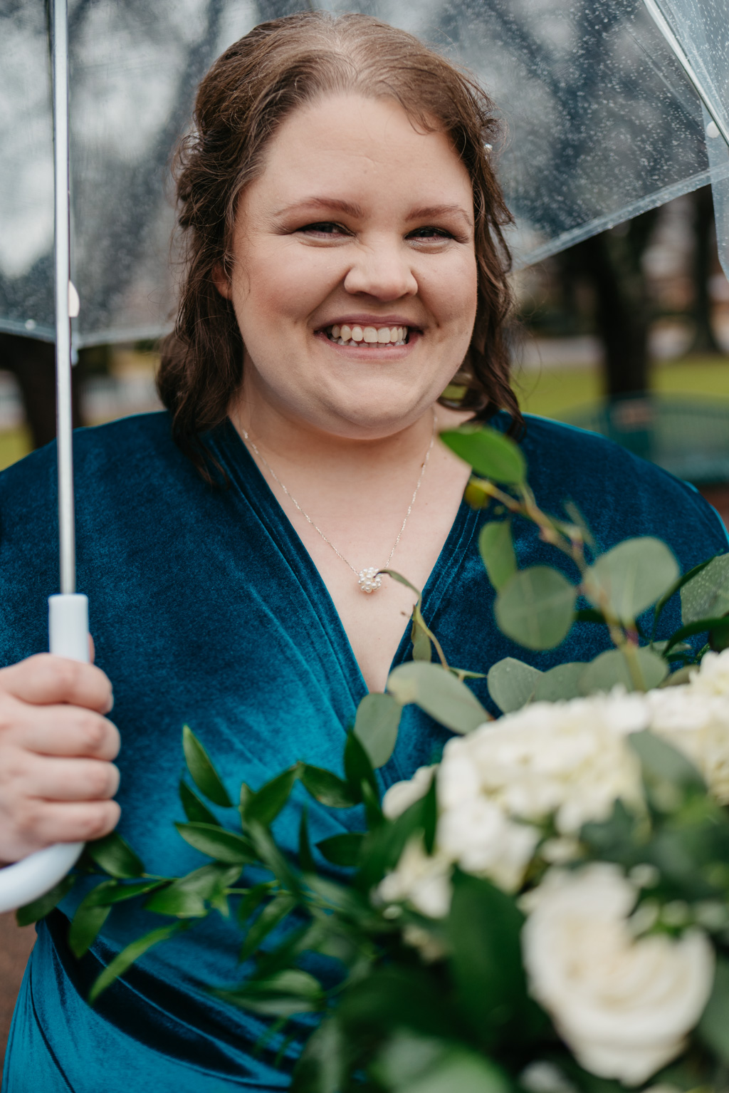 Bride smiling with umbrella