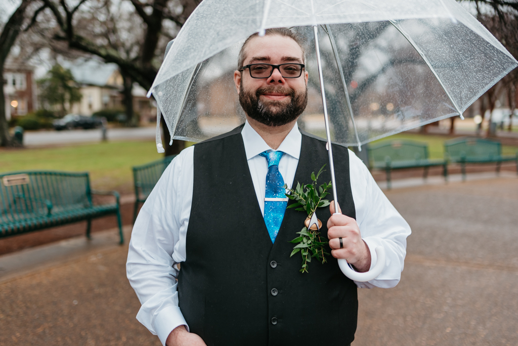 Groom smiling with umbrella