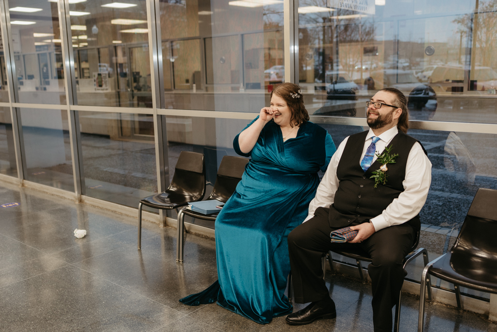 Couple waiting for paperwork at courthouse laughing