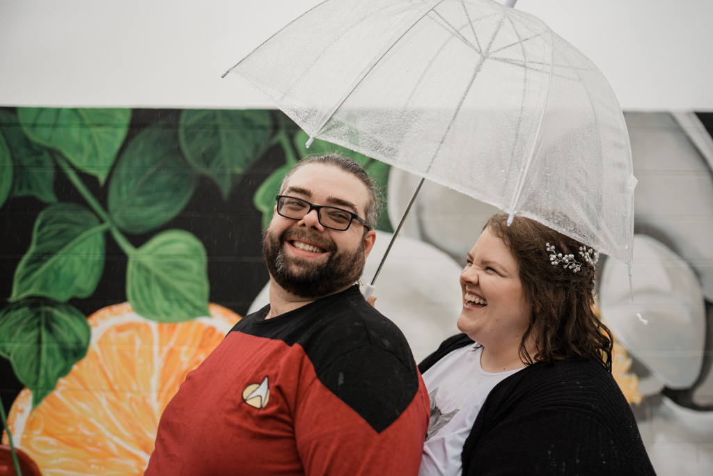 Couple smiling under umbrella