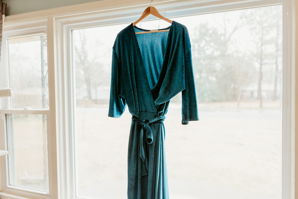 Blue velvet wedding dress hanging from window