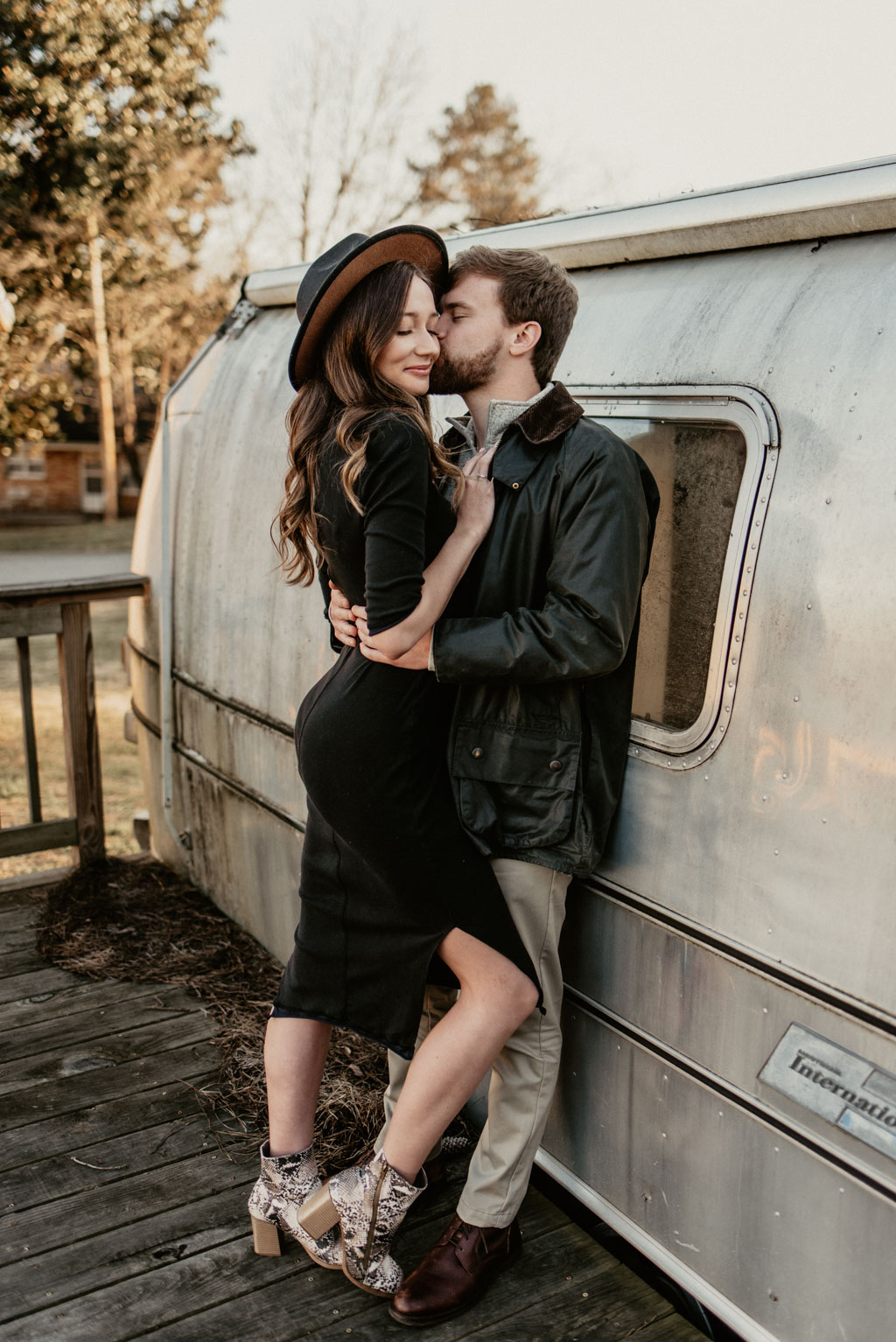 Couple leaning against airstream