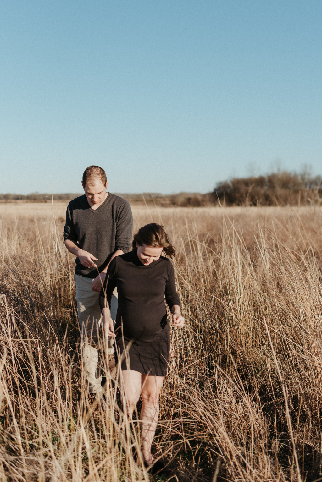 Couple walking out of tall grass field