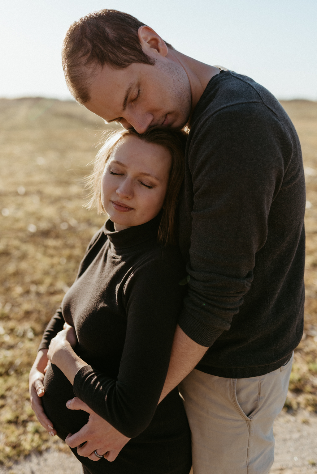 Man hugging pregnant spouse from behind