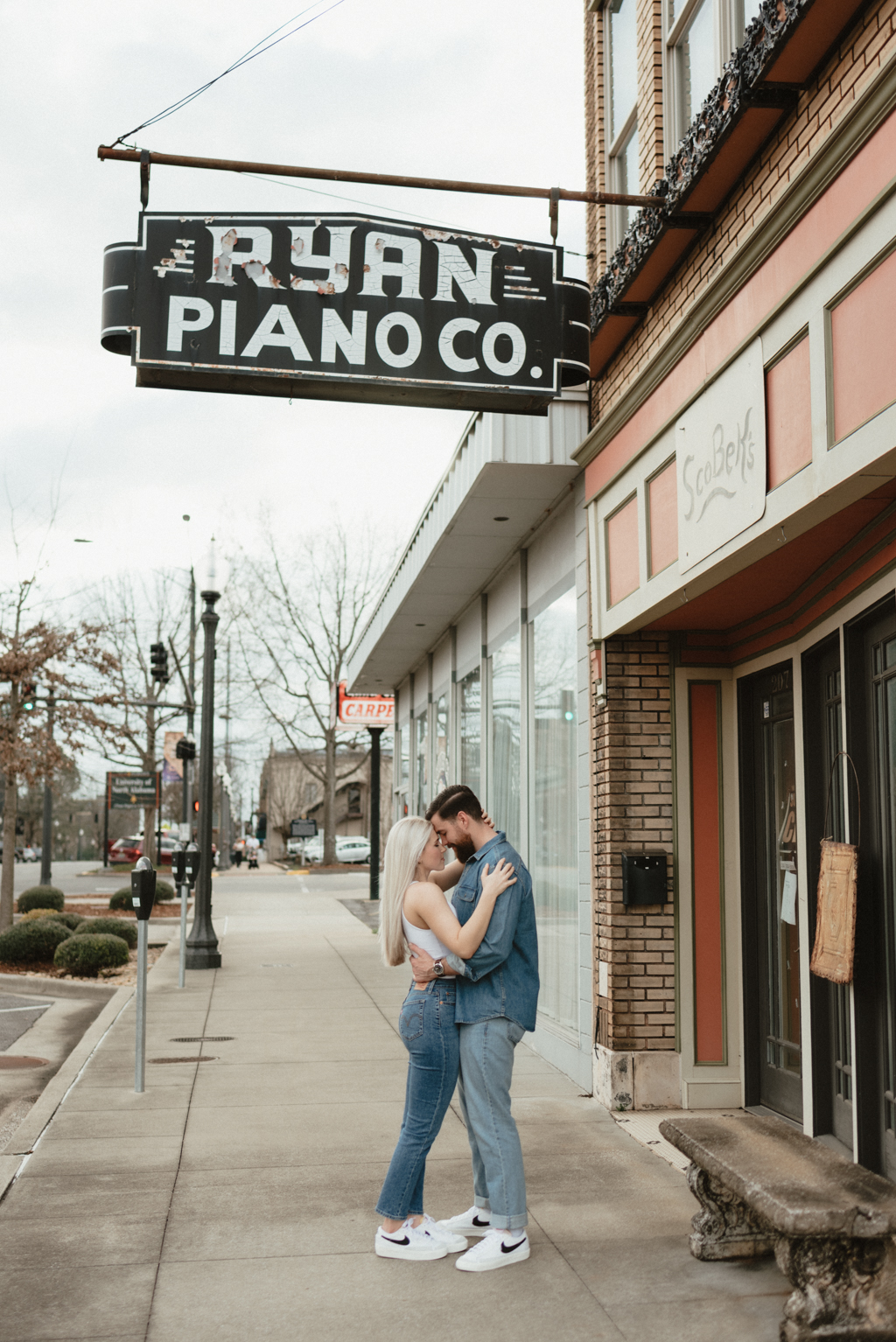 Couple hugging outside of antique piano shop
