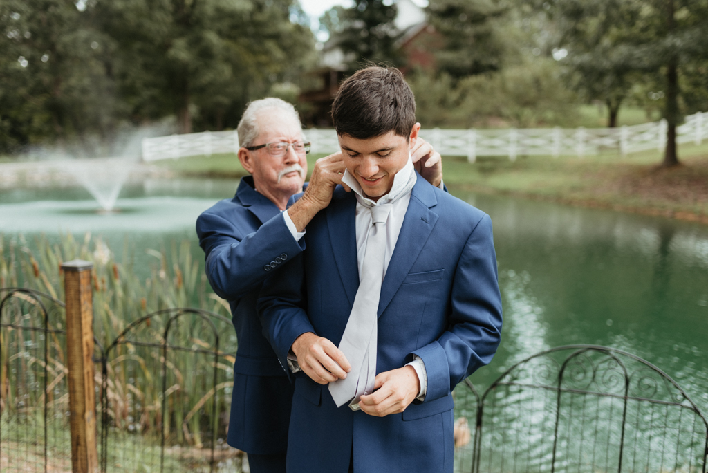 Grandfather helping grandson with tie