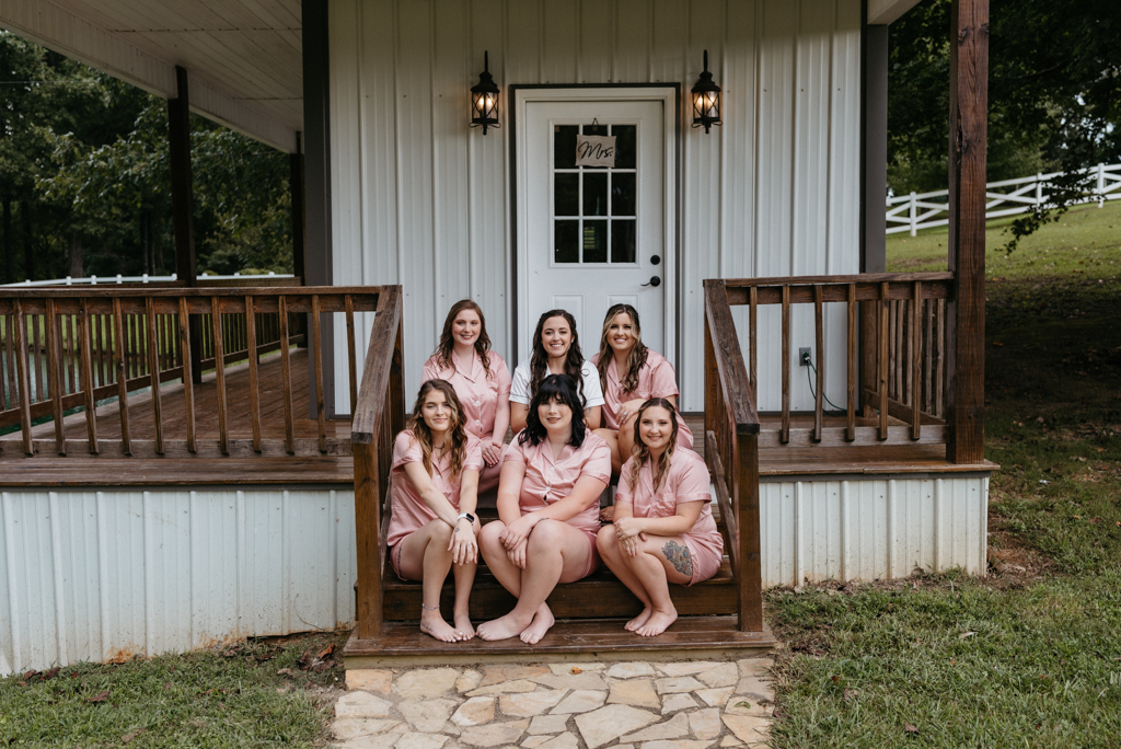 Bridesmaids smiling and sitting on steps