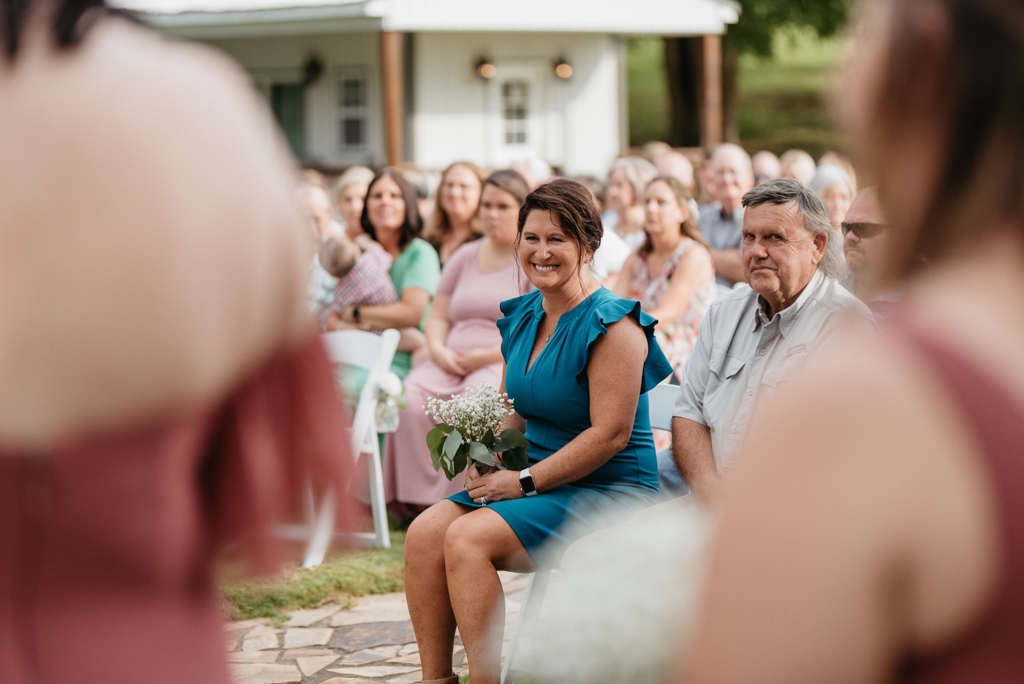 Mother of groom sitting at wedding laughing