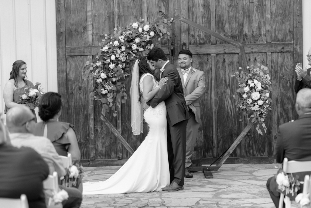 Bride and groom kissing at altar