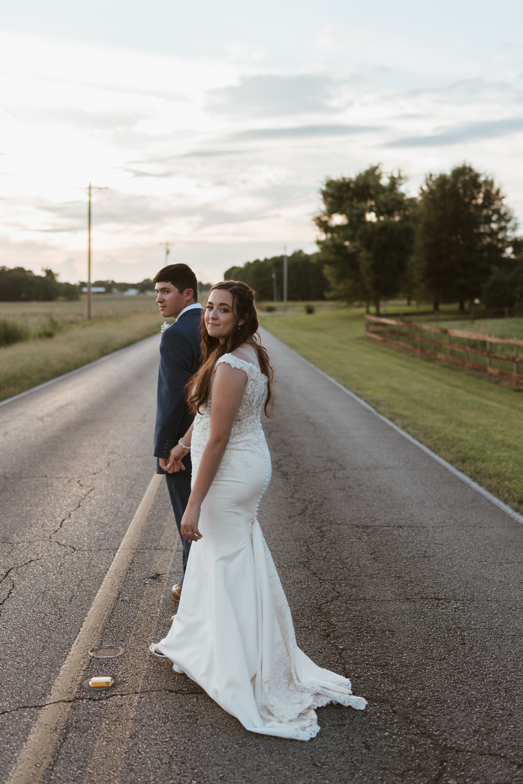 Bride and groom walking away toward the sunset